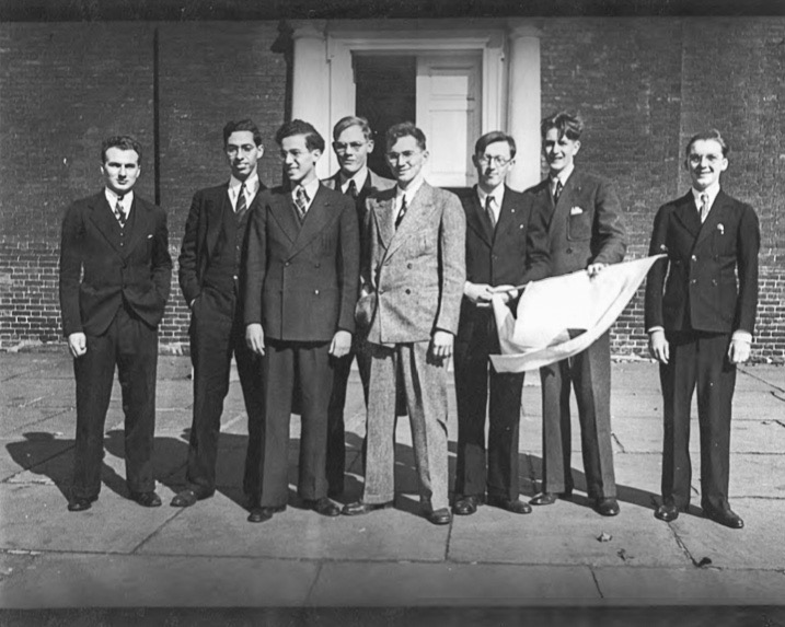 From left to right, the majority of the attendees of Philcon, the world's first science fiction convention: Oswald Train, Donald A. Wollheim, Milton A. Rothman, Frederik Pohl, John B. Michel, William S. Sykora (holding the NYB-ISA flag), David A. Kyle, and Robert Madle. They're standing in front of Independence Hall.